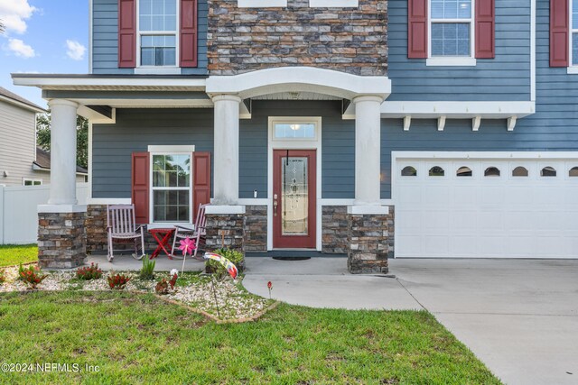 entrance to property featuring a garage and a yard