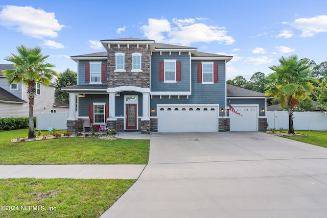 view of front of house featuring a porch, a garage, and a front lawn