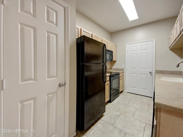 kitchen featuring sink, black appliances, and light tile patterned floors