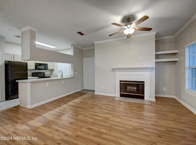 unfurnished living room featuring light hardwood / wood-style floors, sink, ceiling fan, and crown molding