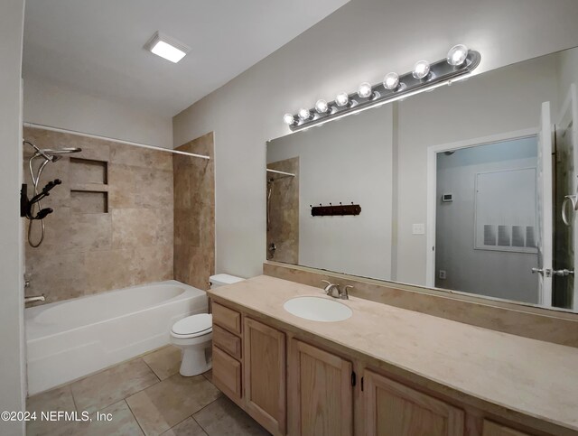 full bathroom featuring toilet, tile patterned floors, tiled shower / bath combo, and vanity