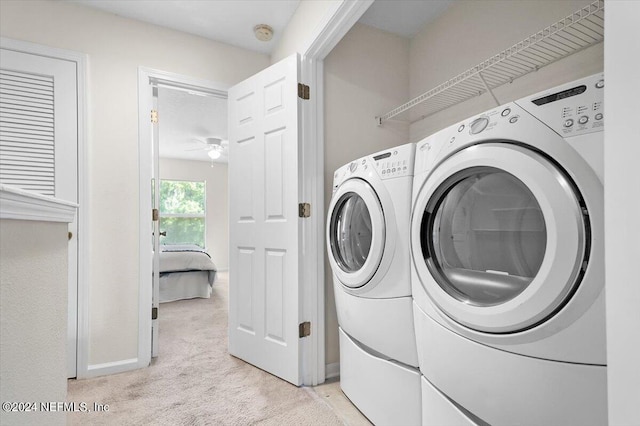 clothes washing area featuring light colored carpet and washer and dryer