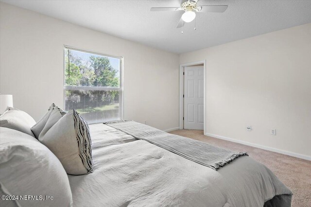 bedroom with light colored carpet and ceiling fan