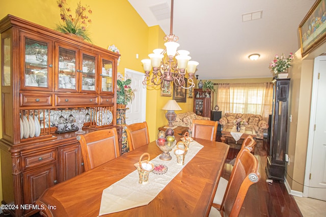 dining area featuring a chandelier and vaulted ceiling