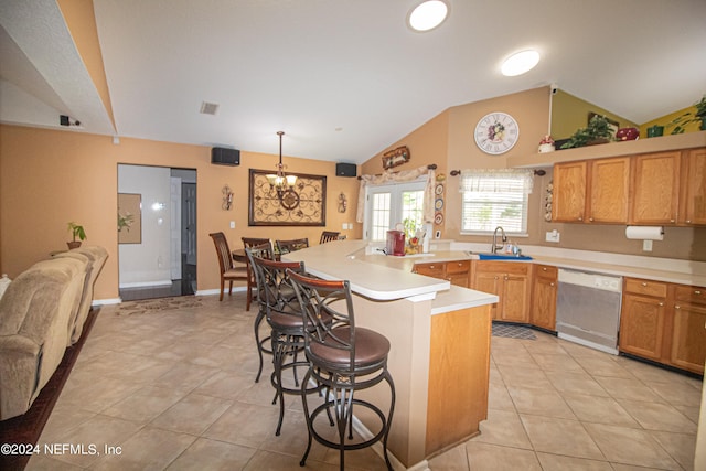 kitchen featuring decorative light fixtures, lofted ceiling, dishwasher, sink, and a breakfast bar area