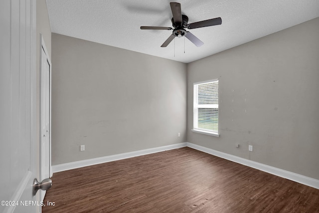 empty room with dark wood-style floors, ceiling fan, a textured ceiling, and baseboards