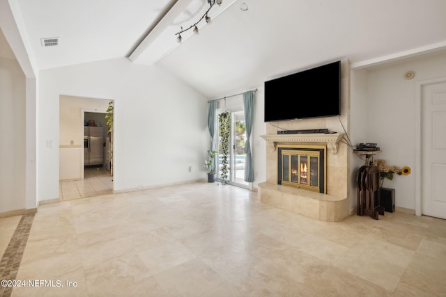 unfurnished living room featuring lofted ceiling with beams, baseboards, visible vents, and a tile fireplace