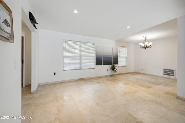 unfurnished living room featuring baseboards, visible vents, a notable chandelier, and recessed lighting