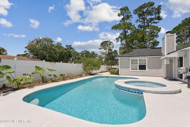 view of swimming pool with a fenced backyard, a pool with connected hot tub, and a patio