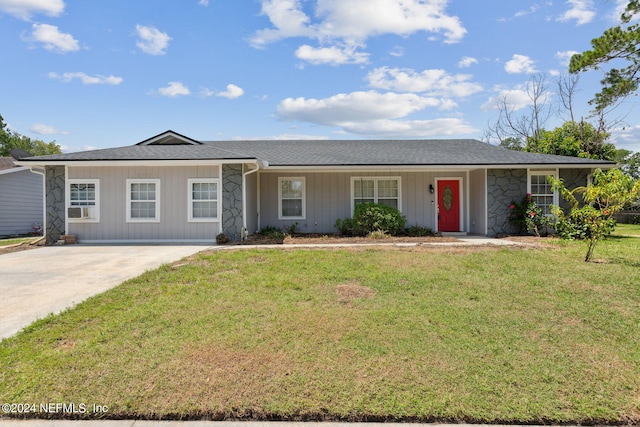 single story home with stone siding, a front lawn, and concrete driveway