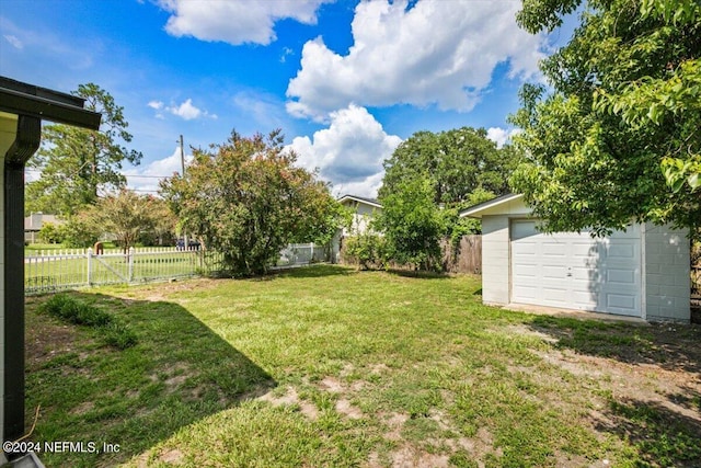 view of yard featuring a garage and an outbuilding