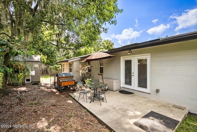 back of property featuring french doors, a storage shed, and a patio area