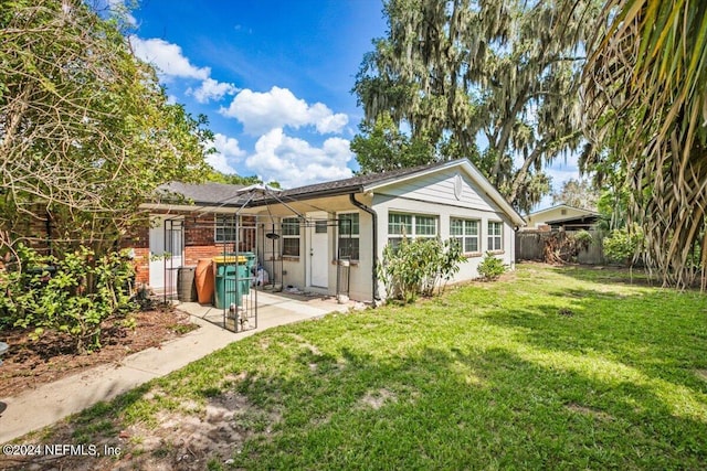 rear view of property with a lawn