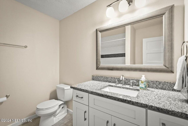 bathroom with vanity, a shower, a textured ceiling, tile patterned floors, and toilet