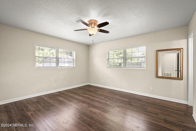 spare room featuring dark hardwood / wood-style flooring, a textured ceiling, and ceiling fan