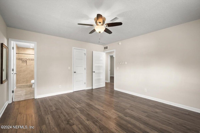 unfurnished bedroom with ceiling fan, connected bathroom, dark hardwood / wood-style floors, and a textured ceiling