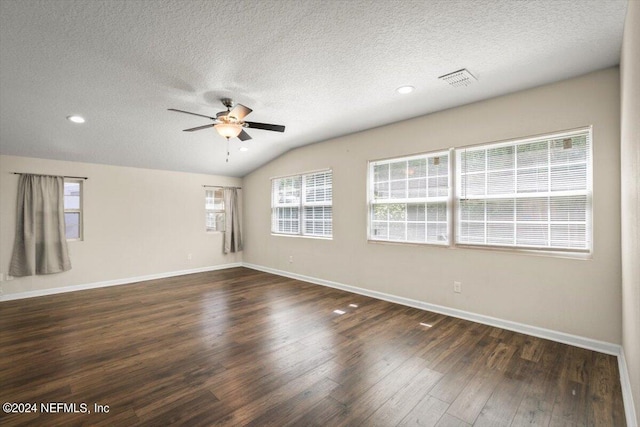 empty room featuring ceiling fan, lofted ceiling, dark hardwood / wood-style floors, and a textured ceiling