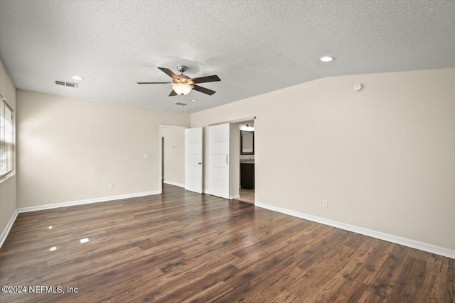 unfurnished room featuring ceiling fan, lofted ceiling, dark wood-type flooring, and a textured ceiling