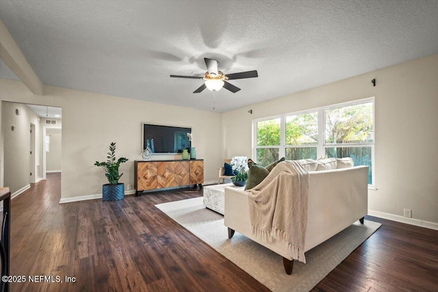 living room with a textured ceiling, dark wood-type flooring, and ceiling fan