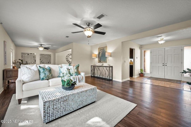 living room with ceiling fan, dark hardwood / wood-style floors, and a textured ceiling