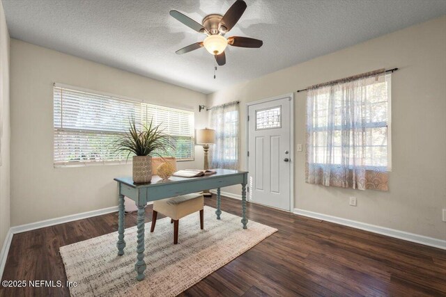 home office featuring ceiling fan, dark hardwood / wood-style flooring, and a textured ceiling