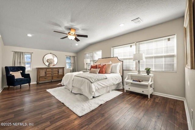 bedroom with a textured ceiling, vaulted ceiling, dark hardwood / wood-style floors, and ceiling fan