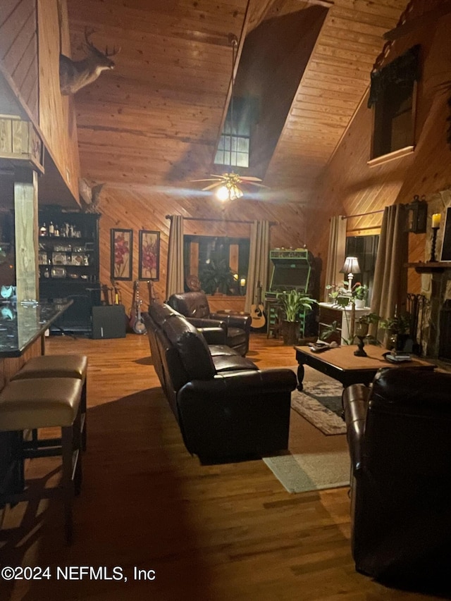 living area with wooden ceiling, wooden walls, high vaulted ceiling, and wood finished floors