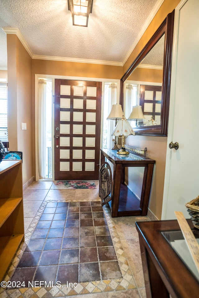 tiled foyer with a textured ceiling and ornamental molding