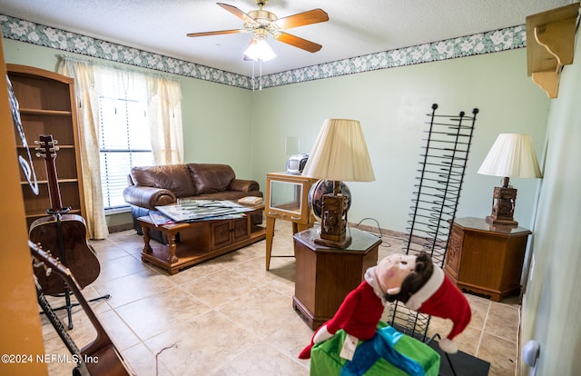 living room featuring a textured ceiling, light tile patterned floors, and ceiling fan