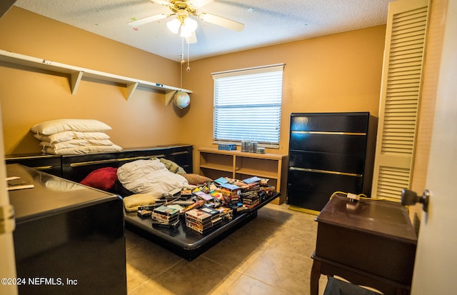 bedroom featuring light tile patterned flooring, a textured ceiling, and ceiling fan