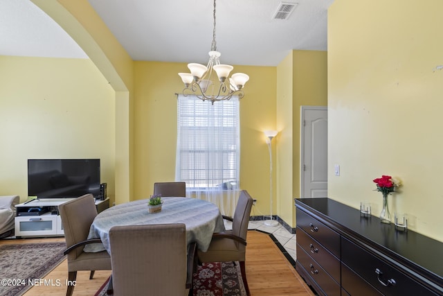 tiled dining space featuring a chandelier