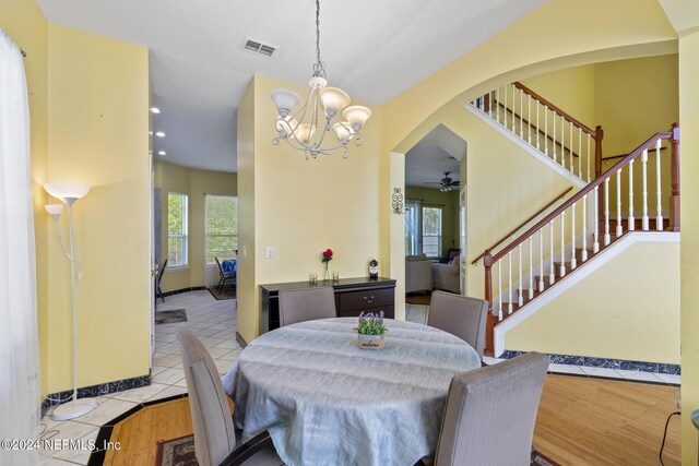 dining room with light tile patterned flooring and a notable chandelier