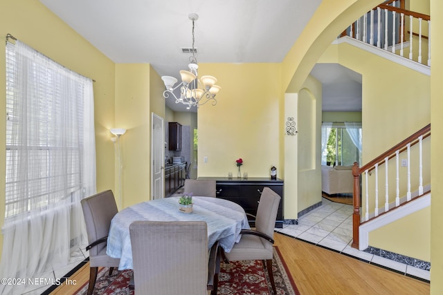 dining area with an inviting chandelier and light hardwood / wood-style flooring