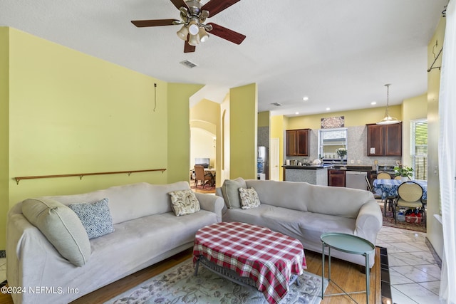 tiled living room with ceiling fan