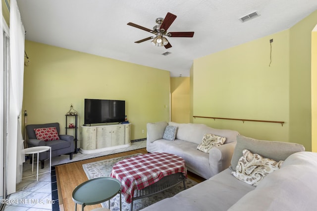 tiled living room with ceiling fan