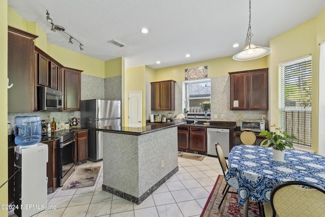 kitchen with decorative backsplash, stainless steel appliances, a healthy amount of sunlight, and a kitchen island