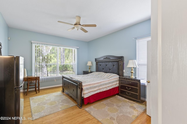 bedroom with stainless steel refrigerator, ceiling fan, and hardwood / wood-style floors