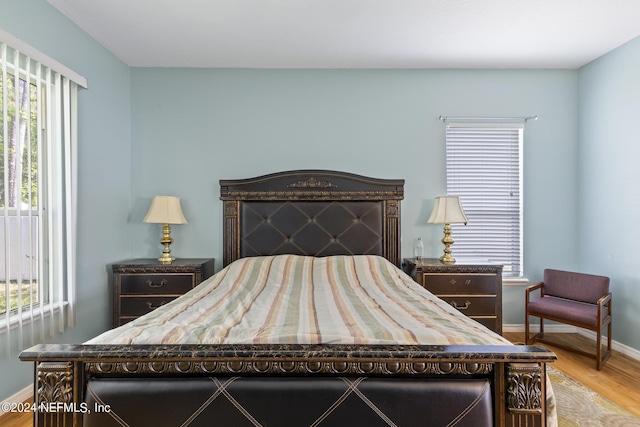 bedroom featuring multiple windows and light hardwood / wood-style floors