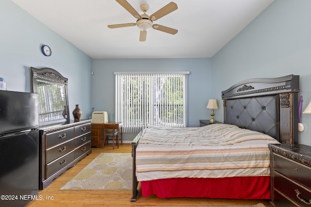 bedroom featuring black fridge, ceiling fan, and light hardwood / wood-style floors