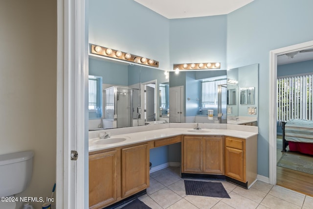 bathroom featuring tile patterned floors, toilet, a shower with door, and vanity