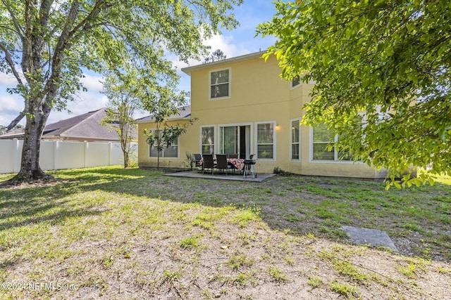 back of property featuring a lawn and a patio