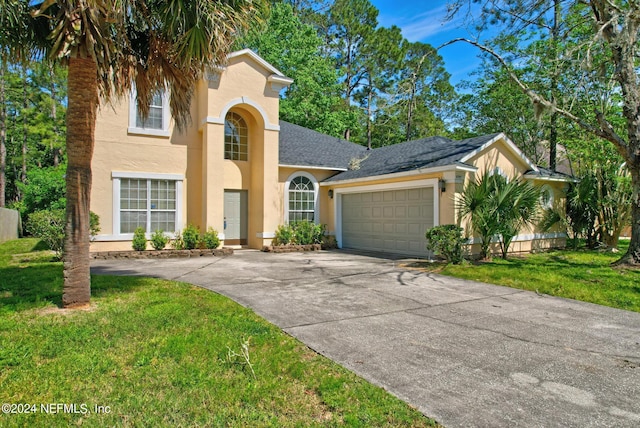 mediterranean / spanish-style house featuring a garage and a front lawn