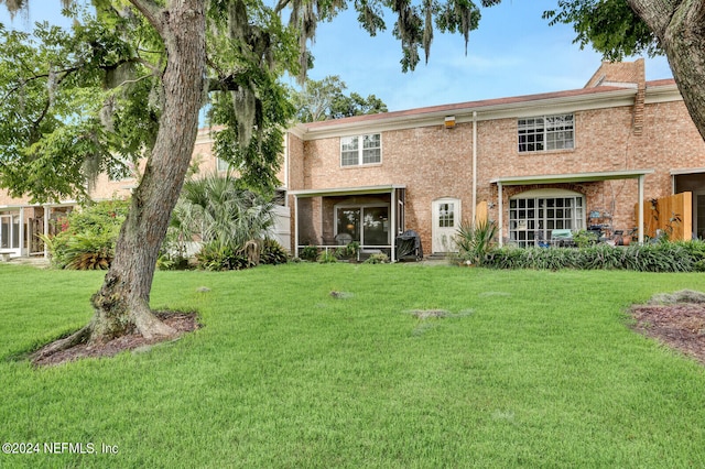 view of front of house featuring a sunroom and a front yard