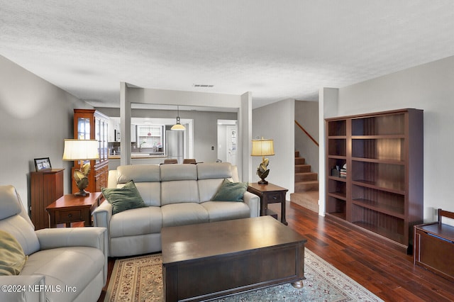 living room featuring a textured ceiling and wood-type flooring