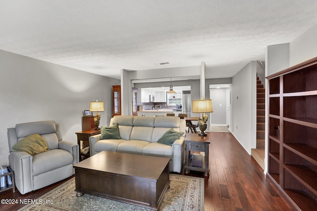 living room featuring wood-type flooring and a textured ceiling