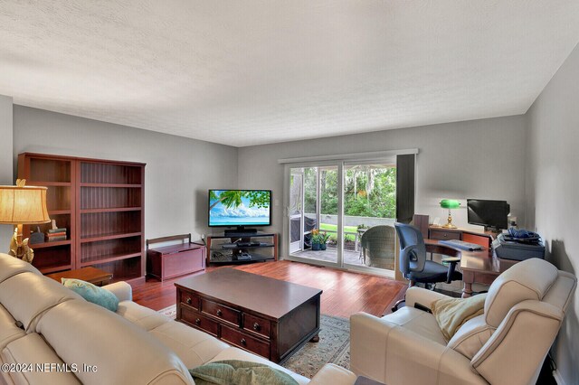 living room featuring hardwood / wood-style flooring and a textured ceiling