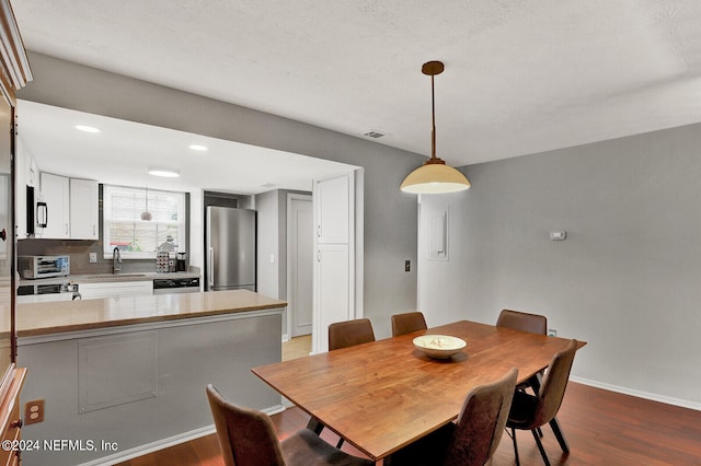 dining room featuring sink and light hardwood / wood-style flooring