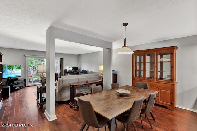 dining room with a textured ceiling and dark wood-type flooring