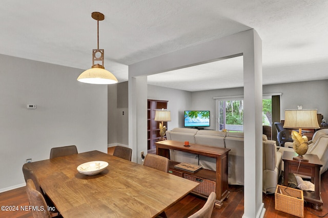 dining space with a textured ceiling and dark hardwood / wood-style flooring