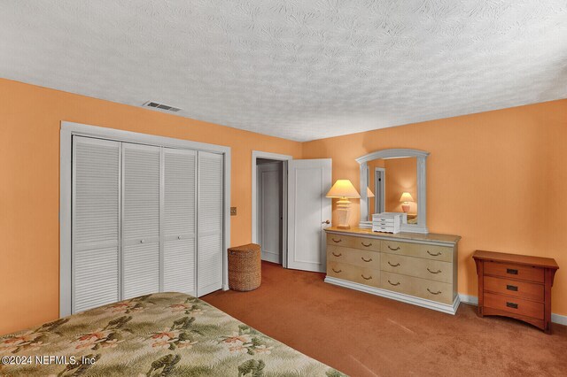 carpeted bedroom featuring a closet and a textured ceiling